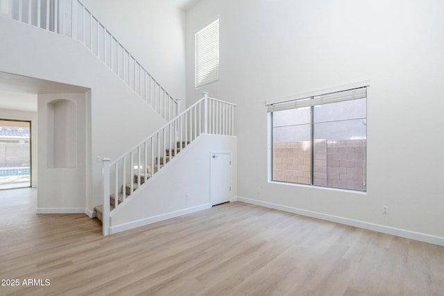 4389 E Muirfield St, Gilbert, AZ 85298 - unfurnished living room with stairway, a high ceiling, and wood finished floors