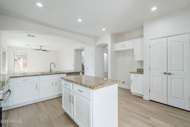 4389 E Muirfield St, Gilbert, AZ 85298 - kitchen featuring arched walkways, a sink, a ceiling fan, and light wood-style floors