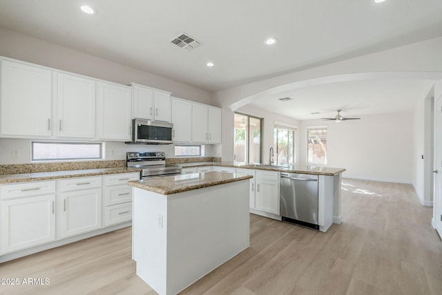 4389 E Muirfield St, Gilbert, AZ 85298 - kitchen featuring visible vents, arched walkways, a sink, appliances with stainless steel finishes, and a peninsula