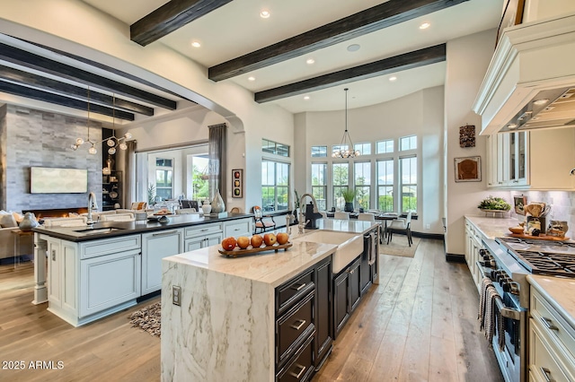 28609 N Cottonwood Basin Dr, Rio Verde, AZ 85263 - kitchen with high end stainless steel range oven, a sink, a chandelier, an island with sink, and beamed ceiling