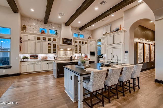 28609 N Cottonwood Basin Dr, Rio Verde, AZ 85263 - kitchen featuring a large island, a high ceiling, arched walkways, a kitchen bar, and beam ceiling