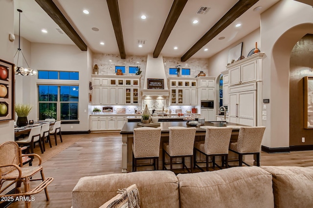 28609 N Cottonwood Basin Dr, Rio Verde, AZ 85263 - kitchen featuring arched walkways, a high ceiling, a large island, a kitchen breakfast bar, and light wood finished floors