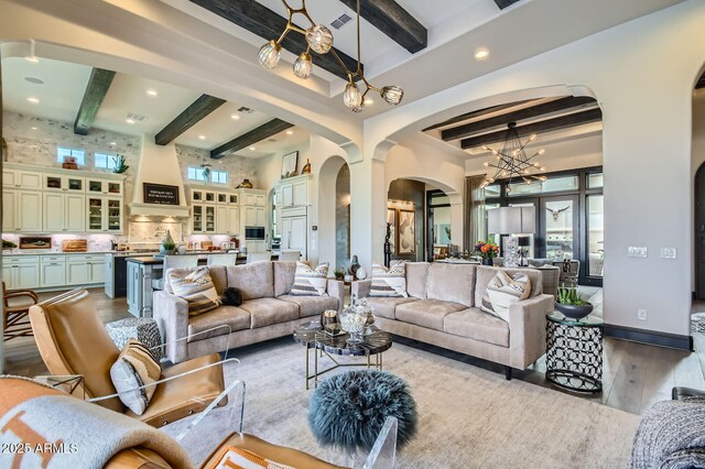 28609 N Cottonwood Basin Dr, Rio Verde, AZ 85263 - living area featuring arched walkways, beam ceiling, wood finished floors, a chandelier, and recessed lighting