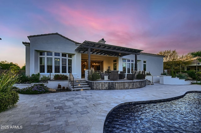 28609 N Cottonwood Basin Dr, Rio Verde, AZ 85263 - back of property at dusk featuring a pergola, stucco siding, a patio, and an outdoor pool