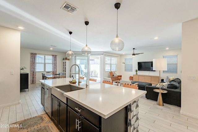 kitchen with a wealth of natural light, visible vents, open floor plan, and a sink