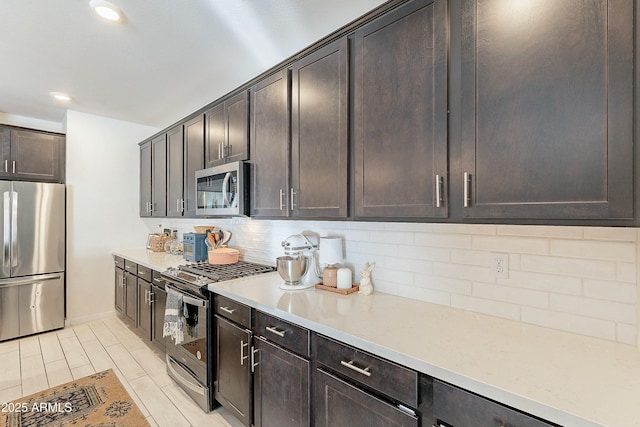 kitchen featuring backsplash, recessed lighting, dark brown cabinetry, appliances with stainless steel finishes, and light countertops