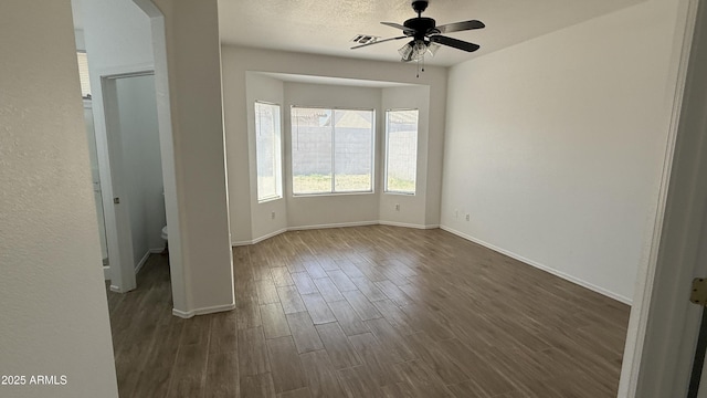 12505 W Adams St, Avondale, AZ 85323 - unfurnished bedroom with dark wood finished floors, arched walkways, and a ceiling fan
