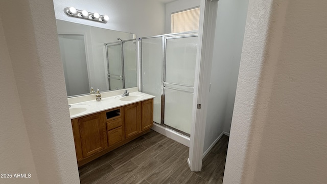 12505 W Adams St, Avondale, AZ 85323 - bathroom featuring a shower stall, wood finish floors, double vanity, and a textured wall