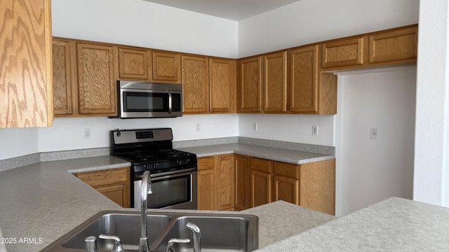 12505 W Adams St, Avondale, AZ 85323 - kitchen featuring appliances with stainless steel finishes, brown cabinets, and light countertops