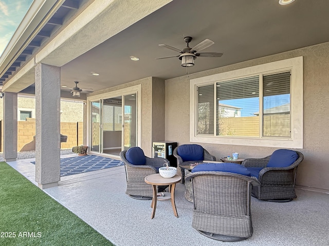 view of patio with an outdoor living space, fence, and ceiling fan