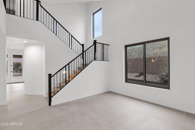 stairway featuring a wealth of natural light and a high ceiling