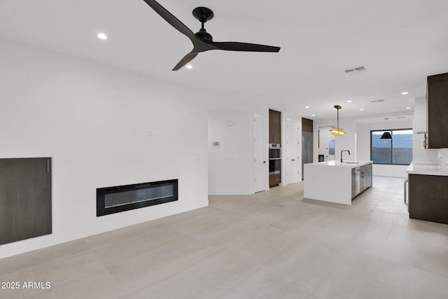 unfurnished living room with sink and ceiling fan