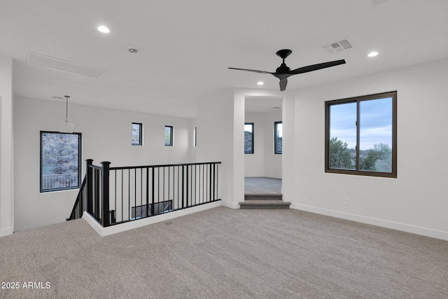 carpeted spare room featuring ceiling fan