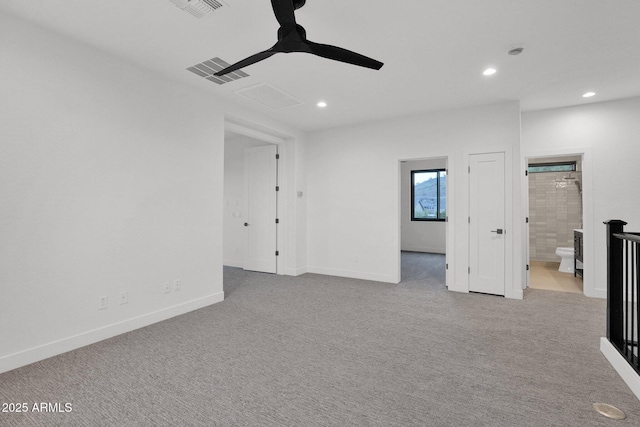 empty room featuring ceiling fan and light carpet