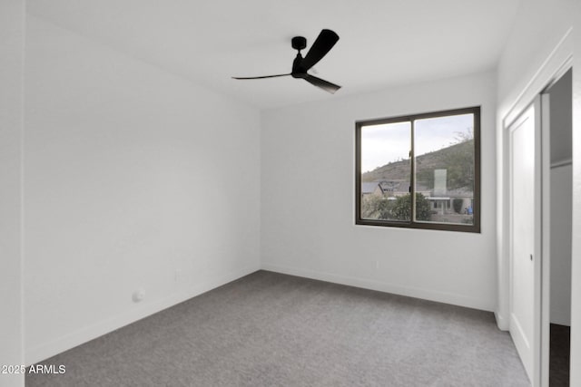 carpeted empty room featuring ceiling fan