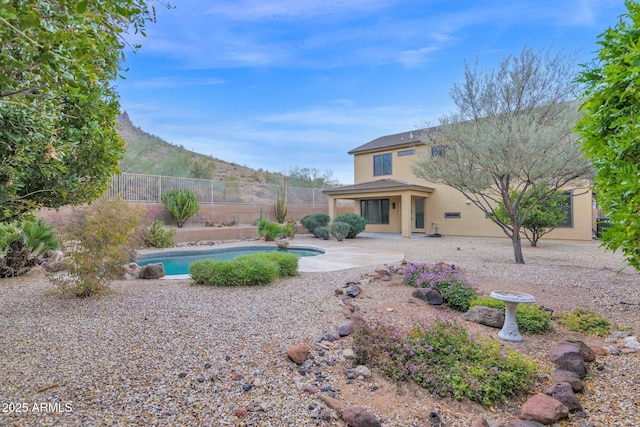 view of yard featuring a fenced in pool, a patio area, and a mountain view