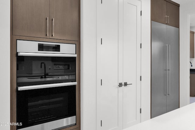 kitchen featuring stainless steel appliances and dark brown cabinets