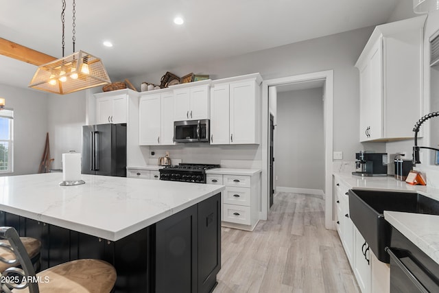 1305 N 22nd Ave, Show Low, AZ 85901 - kitchen featuring high end refrigerator, stainless steel microwave, black range with gas cooktop, a center island, and a sink