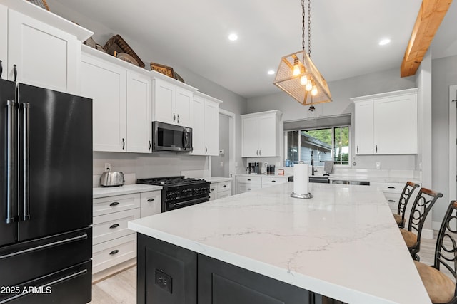 1305 N 22nd Ave, Show Low, AZ 85901 - kitchen featuring black appliances, a center island, white cabinetry, a breakfast bar area, and recessed lighting