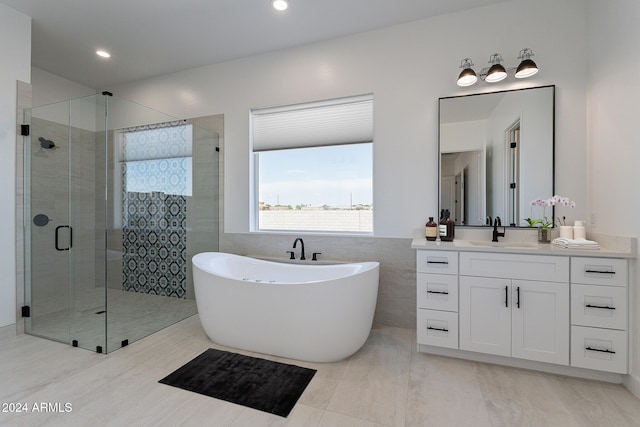 bathroom featuring vanity, tile walls, and plus walk in shower