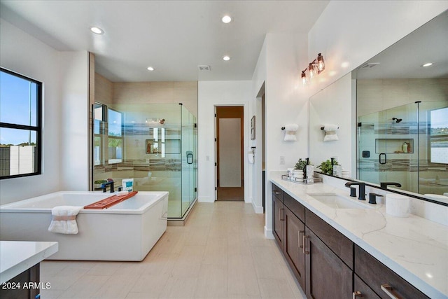 bathroom with vanity and shower with separate bathtub