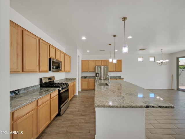 kitchen featuring pendant lighting, a spacious island, an inviting chandelier, sink, and appliances with stainless steel finishes