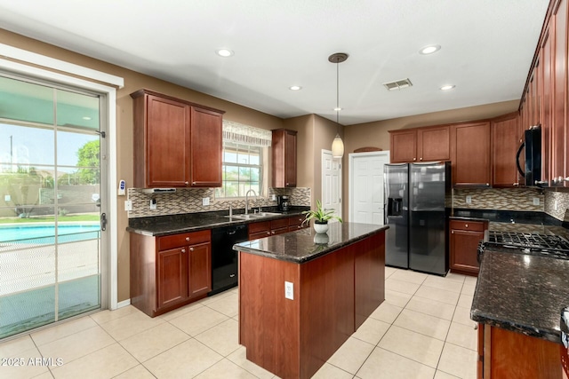 kitchen featuring a sink, black appliances, visible vents, and decorative backsplash