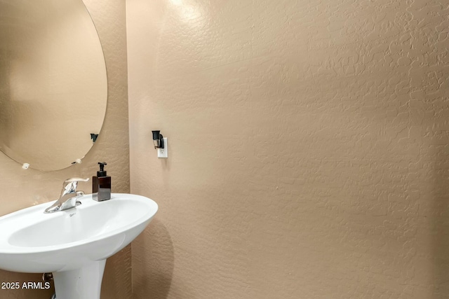 bathroom with a sink and a textured wall