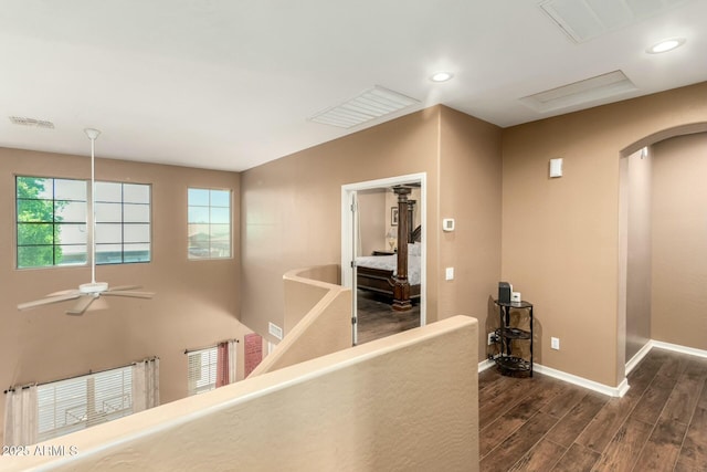 corridor featuring recessed lighting, wood finished floors, arched walkways, baseboards, and visible vents
