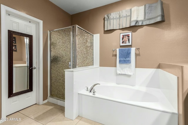 full bath featuring a garden tub, a shower stall, and tile patterned flooring