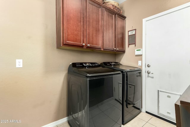 laundry room with light tile patterned floors, washing machine and clothes dryer, and cabinet space