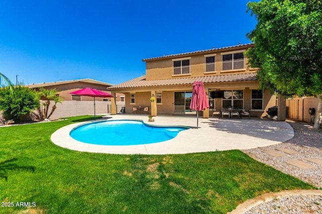rear view of house featuring a fenced in pool, a patio area, a lawn, stucco siding, and a fenced backyard