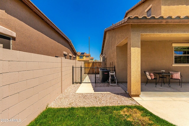 exterior space with a gate, fence, and cooling unit