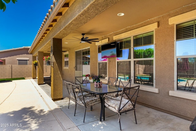 view of patio / terrace with ceiling fan, fence, and outdoor dining space