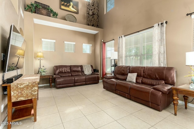 tiled living room with a towering ceiling and baseboards