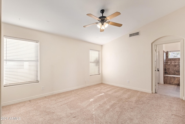 carpeted spare room with ceiling fan and lofted ceiling