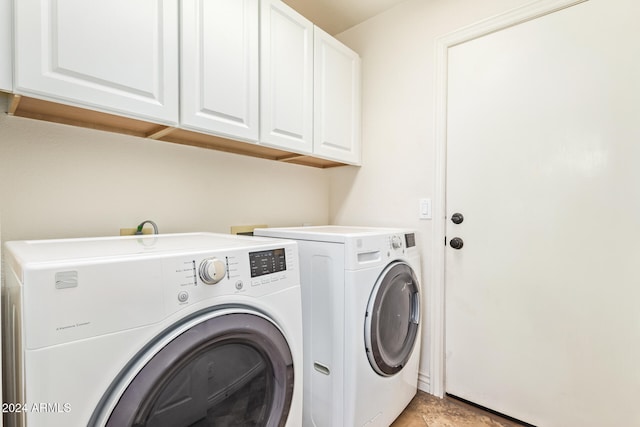 laundry area with washer and clothes dryer and cabinets