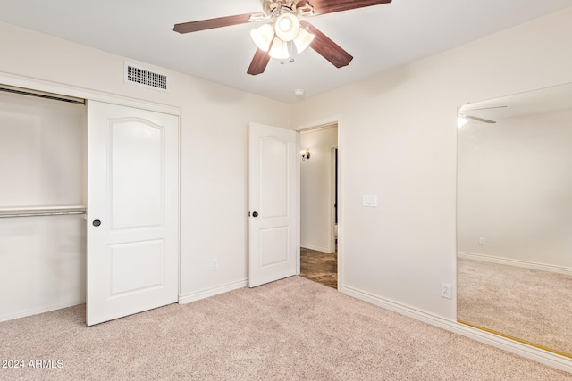 unfurnished bedroom with ceiling fan, a closet, and light carpet