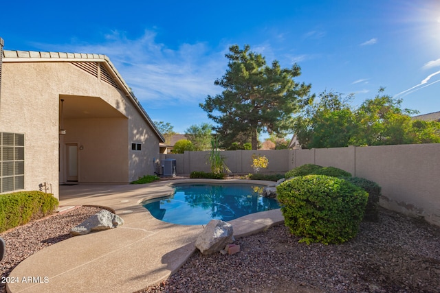 view of pool featuring cooling unit and a patio area