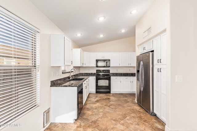 kitchen featuring dark stone counters, black appliances, sink, vaulted ceiling, and white cabinetry