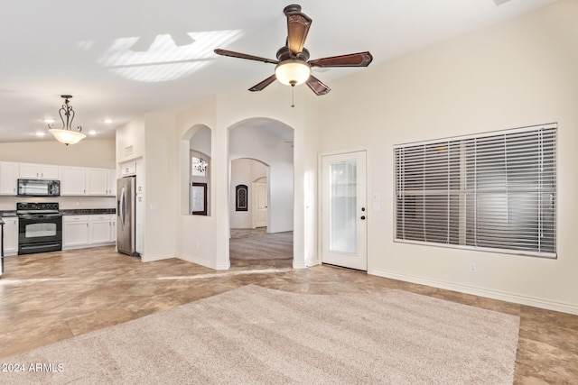 unfurnished living room with ceiling fan and vaulted ceiling