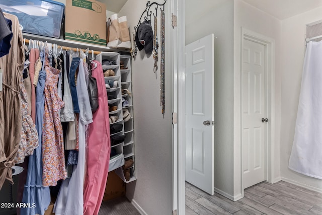 walk in closet with light hardwood / wood-style floors