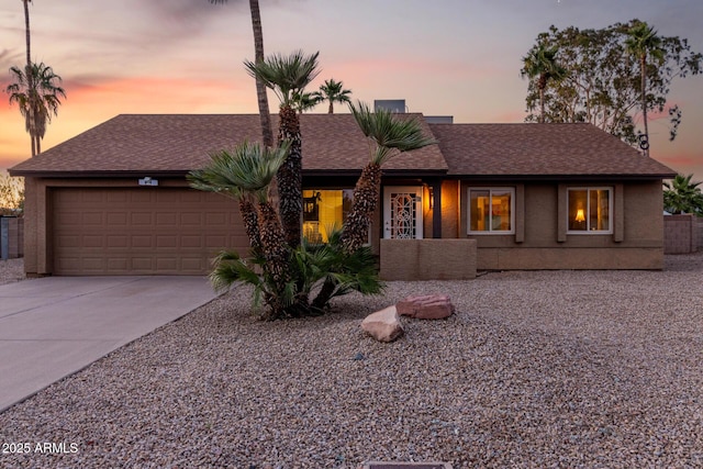 6424 E Aire Libre Ln, Scottsdale, AZ 85254 - view of front facade with a garage, concrete driveway, a shingled roof, and stucco siding