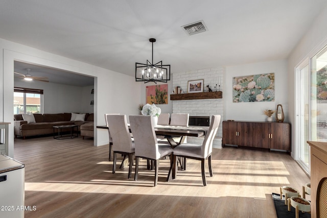 dining room with visible vents, an inviting chandelier, and light wood finished floors