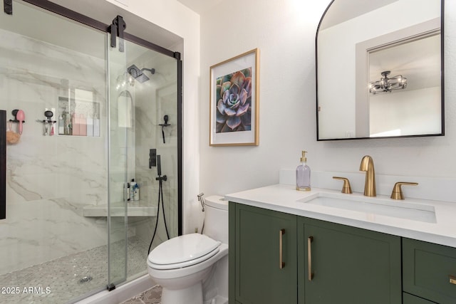 full bathroom with a marble finish shower, toilet, and vanity