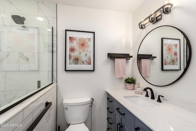 full bath with a tile shower, toilet, and vanity