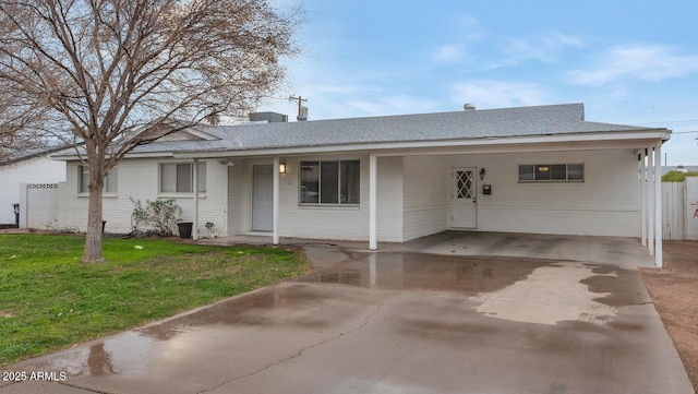 ranch-style home featuring a carport and a front yard