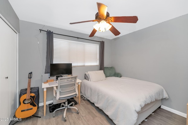 bedroom with light hardwood / wood-style floors, a closet, and ceiling fan