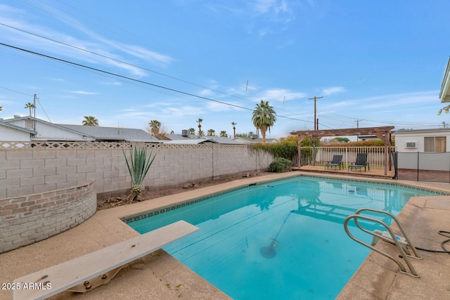 view of swimming pool with a diving board