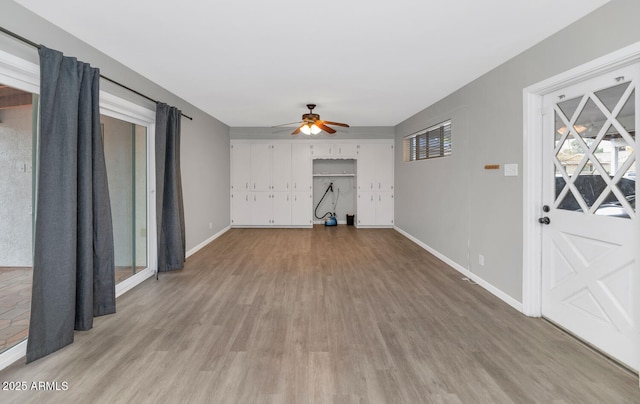 unfurnished living room featuring ceiling fan and light hardwood / wood-style floors